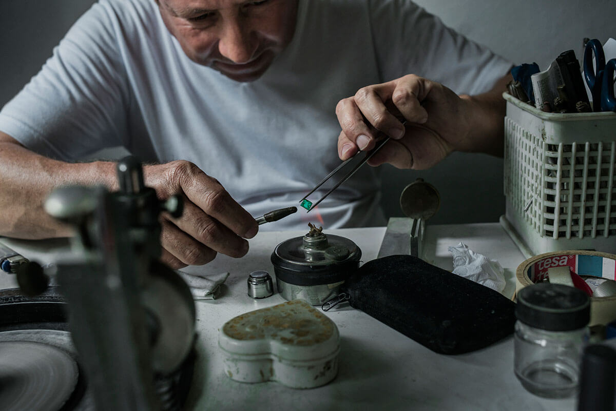 A carver in Muzo, Columbia, polishes an emerald in his workshop located in his house