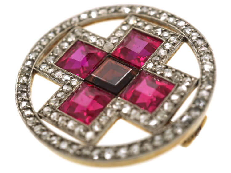 Synthetic rubies were used to decorate this Art Deco Circle Brooch With Cross Motif