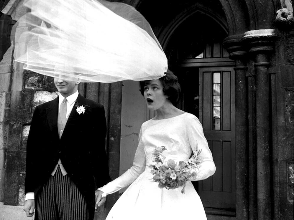 The veil of newly-wed bride Eileen Petticrew flies up in a gust of wind as she poses for photographs with husband Robert Greenhill outside St John the Evangelist Church, Notting Hill, London. (Photo by Evening Standard/Getty Images)