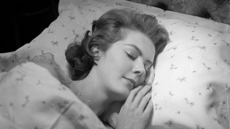 A serene looking woman falls asleep on a matching pillowcase and duvet cover from Harrods department store in London